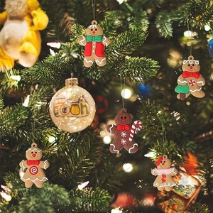 Detail of five assorted gingerbread man charms hanging on a festive Christmas tree