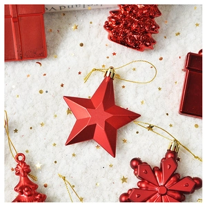 Flat lay of red star and snowflake Christmas ornaments on white faux fur background