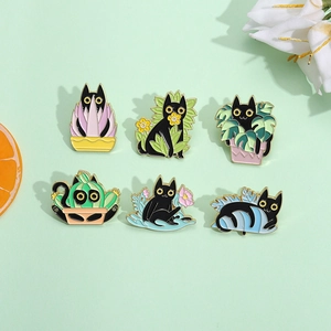 Detail of six cartoon black cat enamel pins featuring various green plants and flowers