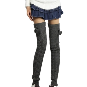 Thick dark grey cable knit over-knee leg warmers with fuzzy pom-poms for winter style