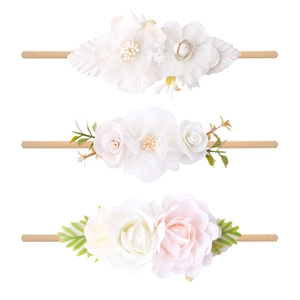 Close-up of three pastoral style elastic nylon headbands with delicate fabric flowers