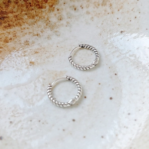 Macro shot of S925 sterling silver stamp on vintage twisted hoop earrings with textured finish