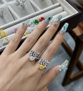 Detail view of leaf-shaped open ring with pear-cut white and yellow gemstones