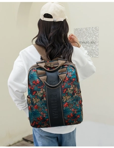 Rear view of model wearing a floral pattern backpack with brown straps and brand detail