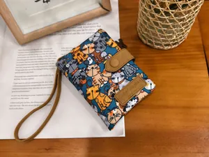 Close-up of printed canvas wallet featuring cartoon cat patterns and leather strap