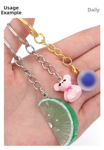 Detailed close-up of lime slice, pink bear, and blue bead DIY metal keychain pendants