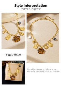 Close-up of gold chunky chain necklace with tortoise flower and vintage religious charms