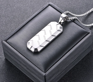Detailed close-up of a silver hexagon tire-tread pendant on a premium black display case
