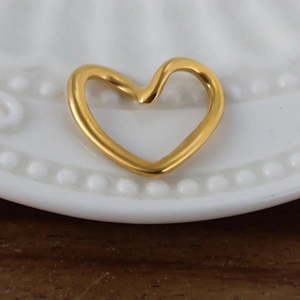 Vue macro d'un pendentif coeur doré sur le bord d'un plat en céramique blanc élégant