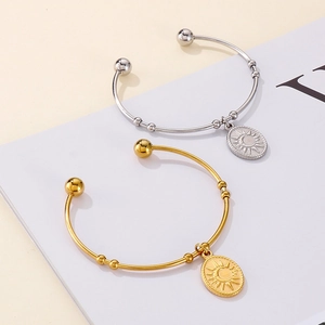 Vue détaillée des bracelets en or et argent avec pendentifs soleil et lune sur fond neutre