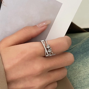 Detail of silver multilayer crossover spinning ring with zircon tassel on hand