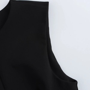 Detail of the crew neck and shoulder seam on a fitted black sleeveless vest