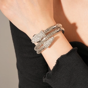 Macro detail of silver snake bracelet with sparkling pavé rhinestones on black sleeve