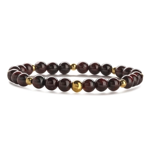 Macro shot of 6mm garnet beads and gold metal spacers on a stretch beaded bracelet