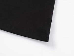 Détail du t-shirt noir en modal montrant les coutures de l'ourlet et la texture du tissu
