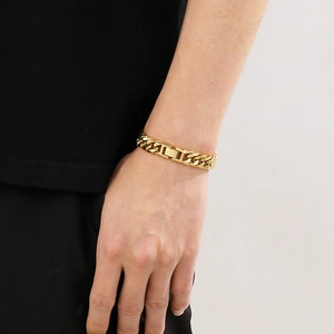 Close-up of a 12mm golden titanium steel curb chain bracelet worn on a male wrist