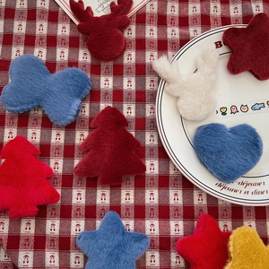 Close-up of handmade plush Christmas tree and star ornaments on a festive plaid cloth
