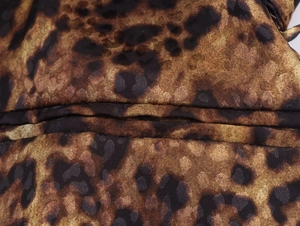 Vista macro de la tela con estampado de leopardo y detalles de doble costura de calidad