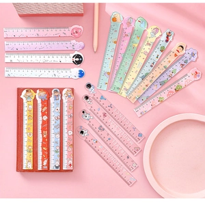 Flat lay of colorful 15cm cartoon rulers and bookmarks on a pink study desk