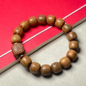 Gros plan d'un bracelet en bois de santal avec perle gravée et texture lisse polie