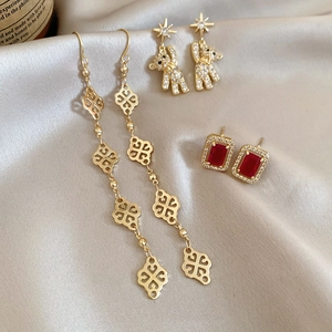 Macro view of assorted bow and flower earrings on elegant champagne satin fabric
