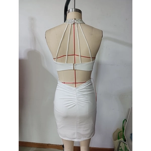 Close-up of white halter neck dress with sparkling rhinestones and open back details