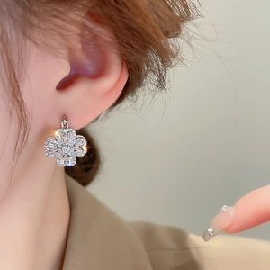 Sparkling silver clover earrings with inlaid zircons on model for elegant look