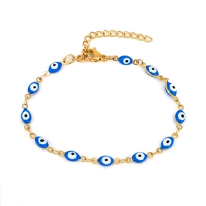 Detail of gold evil eye bracelet featuring blue enamel charms and adjustable chain clasp