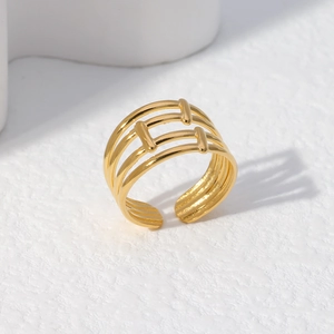 Detail of gold geometric triple-layer stacked open ring on a marble surface