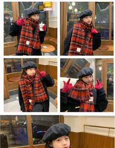 Detail of red plaid winter scarf set with grey beret and gloves in a cozy cafe setting