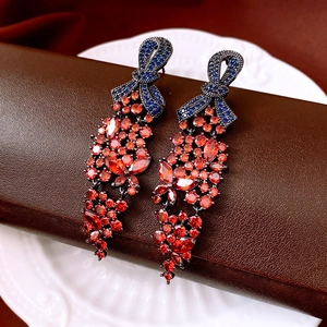 Vue détaillée de boucles d'oreilles nœud vintage avec pierres bleues et franges de zircon