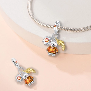 Detail of silver bear charm with orange gems, sun and wheat pendants on bracelet