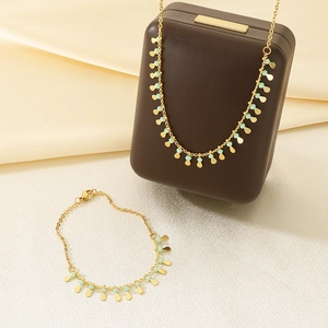 Detailed shot of golden tassel necklace and bracelet set with turquoise beads and charms