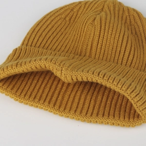 Close-up macro detail of a soft and warm mustard yellow ribbed knit winter beanie