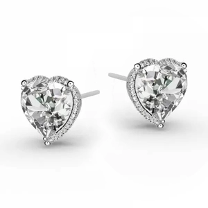 Macro view of heart-shaped silver earrings featuring halo cubic zirconia and claw setting