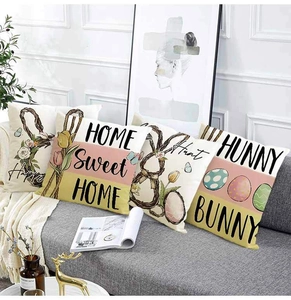 Set of four Easter linen pillow covers with bunny and floral prints on a gray sofa