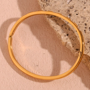 Close-up of 18K gold plated bangle featuring micro-set zircon and screw motif details