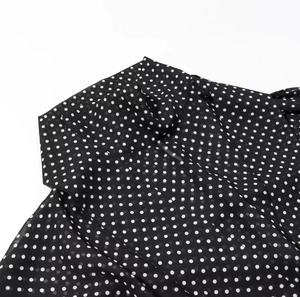 Detailansicht des schwarz-weiß gepunkteten Chiffonstoffs mit eleganter Kragennaht