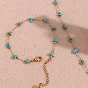 Close-up of 18K gold plated chain with turquoise stone fragments and lobster clasp detail
