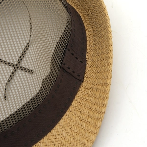 Detail of hand-woven straw sun hat showing brown ribbon and breathable mesh lining
