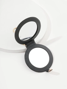 Detail view of a black round PU leather folding mirror with golden metal ring keychain