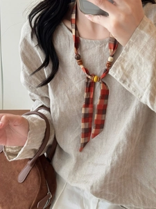 Ethnic style fabric necklace with wooden beads shown on model for a vintage look