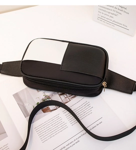 Vue de dessus d'un sac banane bicolore noir et blanc en similicuir avec zip doré chic