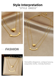 Détail du collier double rang doré avec pendentifs en forme de cœur et sourire