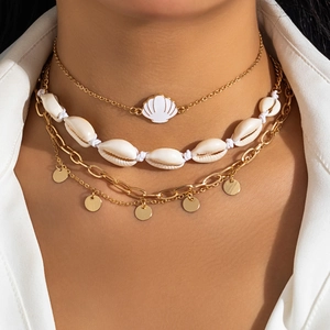 Detail of layered bohemian necklace with golden shell charms and starfish pendants on model