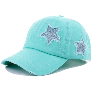 Detail of mint green washed baseball cap featuring glittery blue star patches with frayed edges