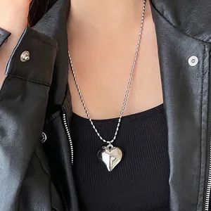 Minimalist silver 3D heart pendant necklace with fine ball chain on black outfit