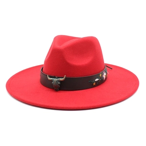 Detail of red fedora hat featuring a bull head buckle and floral embroidery band