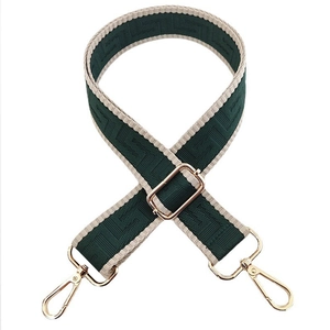 Detail of adjustable wide purse strap with dark green Greek Key pattern and gold hardware