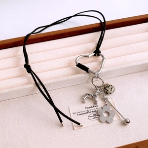 Close-up of heart-shaped carabiner necklace with dog charm and spotted stone bead